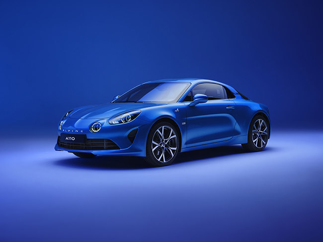Ein blauer Alpine A110 Sportwagen vor einem blauen Hintergrund, elegant mit Sportfelgen und modernem Design.